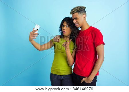 Taking Selfie Or Vlog Together. Young Emotional African-american Man And Woman In Colorful Clothes O