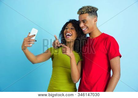 Taking Selfie Or Vlog Together. Young Emotional African-american Man And Woman In Colorful Clothes O