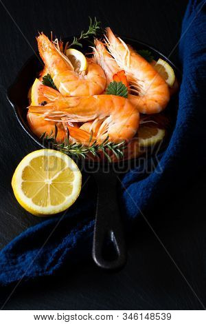Seafood Concept Ocean King Prawns Cooked In Skillet Iron Cast On Black Slate Stone With Blue Napkins