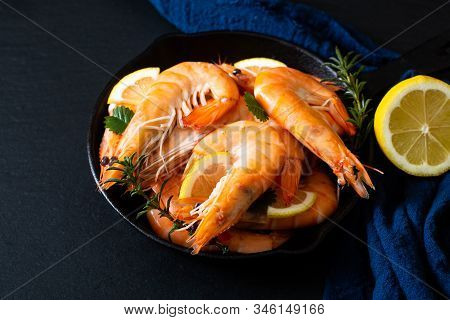Seafood Concept Ocean King Prawns Cooked In Skillet Iron Cast On Black Slate Stone With Blue Napkins