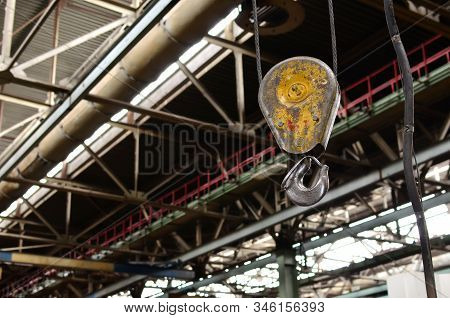 Crane Hook Of The Overhead Crane In The Workshop Of An Industrial Plant. Push Remote Control Switch