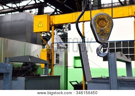Crane Hook Of The Overhead Crane In The Workshop Of An Industrial Plant. Push Remote Control Switch