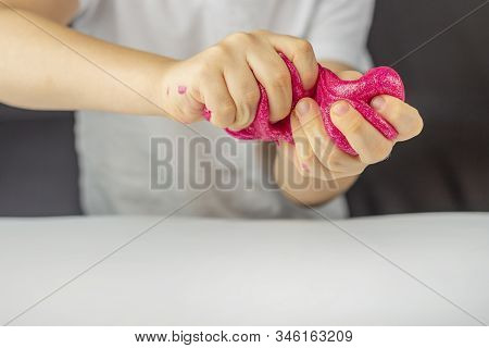 Kid Plays With A Homemade Pink Glitter Slime. Child  Hands Stretch Slime Toy. Make Slime At Home. Th