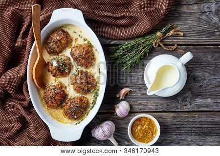 Rabbit Ballotine In A Creamy Mustard Sauce With Herbs And Spices In A Baking Dish On A Rustic Wooden