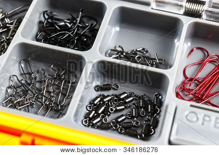 Opened Tackle Box With Fishing Hooks And Accessories. Fishing Hooks In Box Sections. Case For Tackle