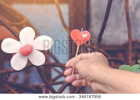 A Red Heart-shaped Candle On Woman's Hand And An Artificial Flower Made Of White And Red Candles Wit