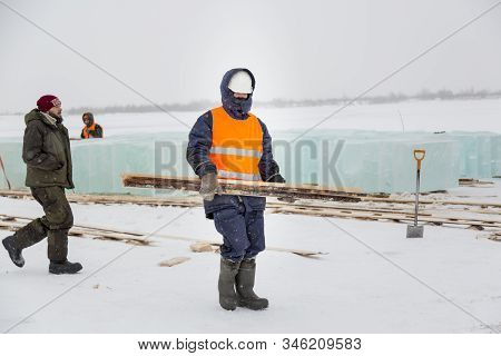 A Slinger In A White Helmet Is Walking On The Installation Site