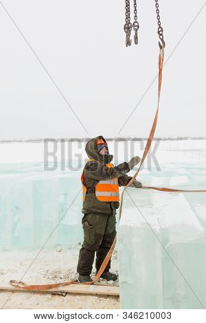 Slinger In Orange Helmet On Shipment Of Ice Blocks