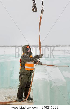 Slinger In Orange Helmet On Shipment Of Ice Blocks