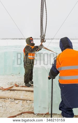 Slinger In Orange Helmet On Shipment Of Ice Blocks