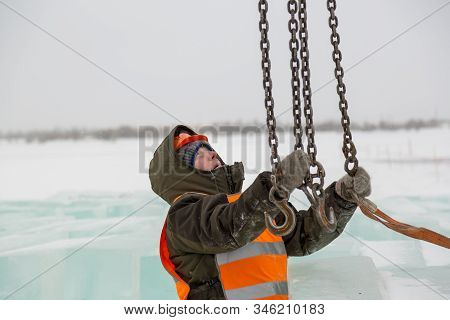 Slinger In Orange Helmet On Shipment Of Ice Blocks
