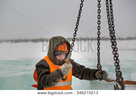 Slinger In Orange Helmet On Shipment Of Ice Blocks