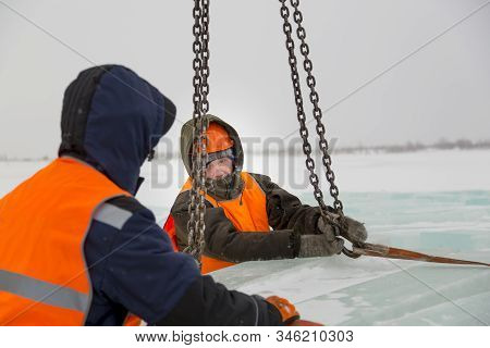 Slinger In Orange Helmet On Shipment Of Ice Blocks