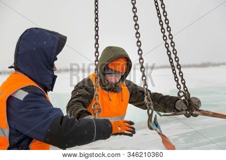 Slinger In Orange Helmet On Shipment Of Ice Blocks