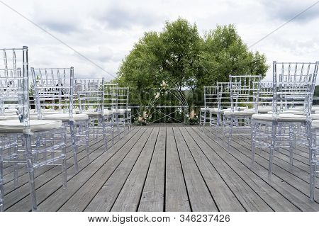 Chiavari Chairs Are Transparent, At A Beautiful Wedding Event. Beautiful Wedding Arch.