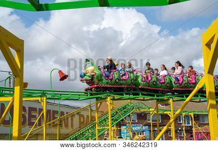Dymchurch England - August 19 2019; Amusement Park  Caterpillar Roller Coaster Being Ridden By Adult