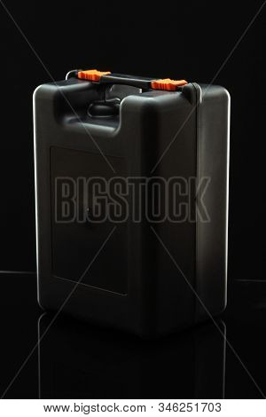 Black Plastic Elongated Caase With A Handle And Two Orange Snaps On A Black