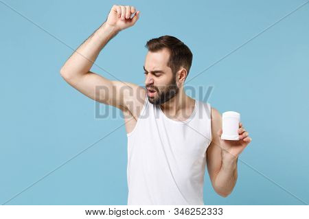 Bearded Young Man 20s Years Old In White Shirt Hold Using Antiperspirant Isolated On Blue Pastel Wal