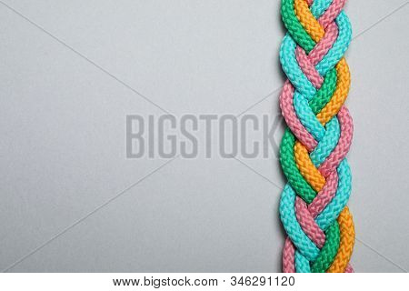 Top View Of Braided Colorful Ropes On Light Grey Background, Space For Text. Unity Concept