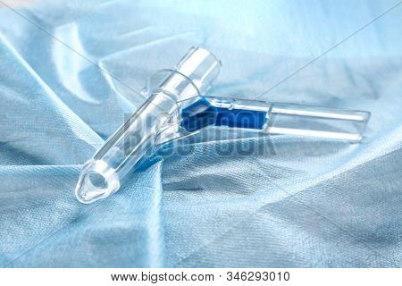 Anoscope On Light Blue Fabric. Hemorrhoid Treatment