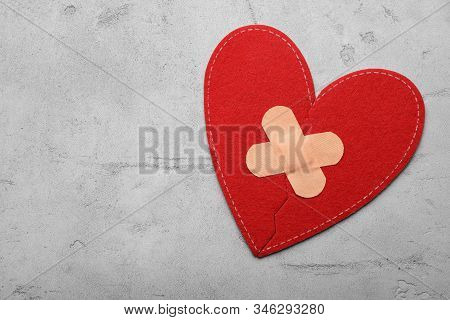 Red Fabric Heart With Sticking Plasters On Light Grey Stone Table, Top View. Space For Text