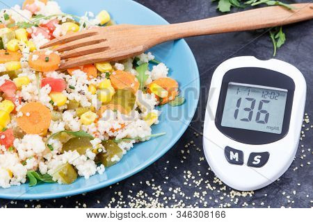 Glucose Meter For Checking Sugar Level And Fresh Salad With Vegetables And Couscous Groats. Light An