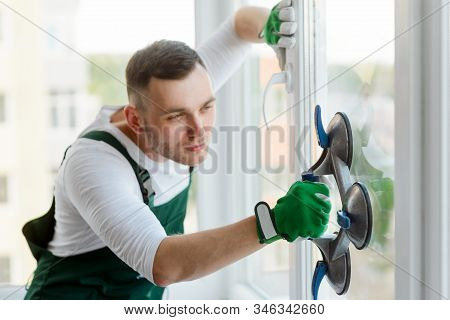 Replacing A Glass Unit. Concetrated Man Is Using A Vacuum Cups