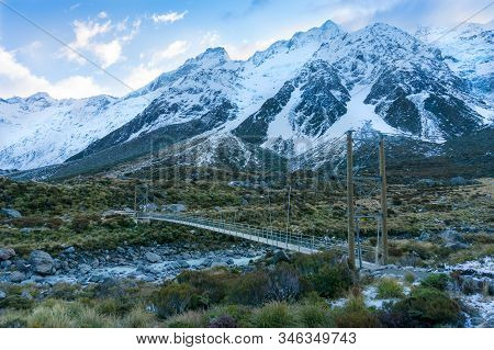 Hiking In Moutnains Landscape With Suspension Bridge And Snow Covered Mountains. Hooker Valley At Ao