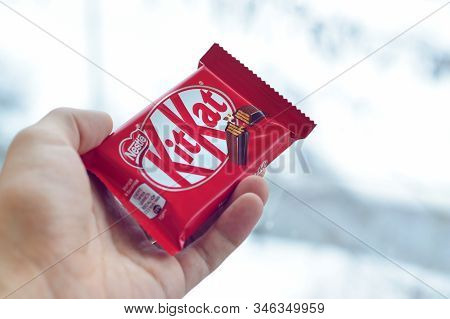 Kit Kat Chocolate Bar In Male Hand On Snowy Background. Kit Kat Created By Rowntrees Of York In Unit