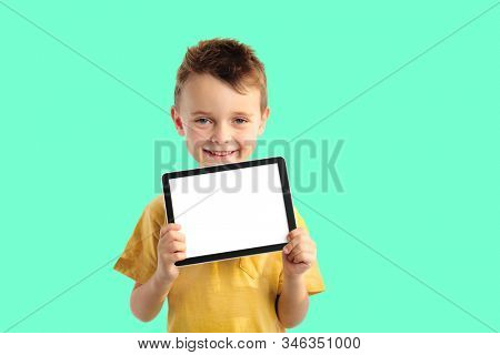 Happy child boy  holding a tablet ipade for your information on the Aqua Menthe background 
