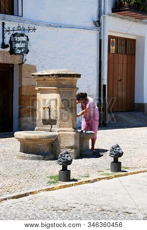 Ubeda, Spain - July 28, 2008 - Girl Taking Water From A Drinking Fountain In The Plaza Santa Lucia, 
