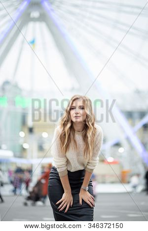 Gorgeus Blonde Woman In Leather Skirt Posing On The Ferris Wheel Background