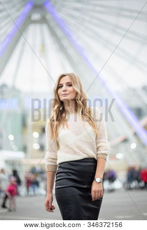Gorgeus Blonde Woman In Leather Skirt Posing On The Ferris Wheel Background