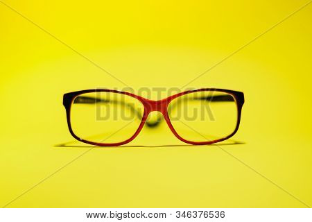 Red Black Glasses On The Yellow Background.