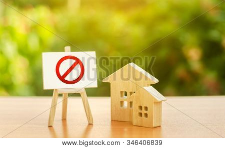 Wooden Houses And An Easel With A Red Prohibition Sign No. Inaccessibility And Lack Of Housing, Defi