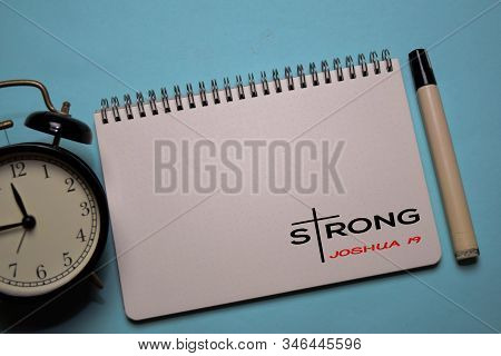Strong - Joshua One Nine Write On A Book Isolated On Office Desk. Christian Faith Concept