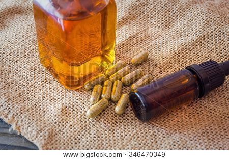 Glass Bottle With Cannabis Cbd Thc Oils And Cbd Pills On Hemp Cloth, Medical Marijuana Concept