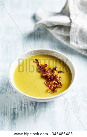 Cream of potato and leek soup with turmeric, topped with caramelized challots