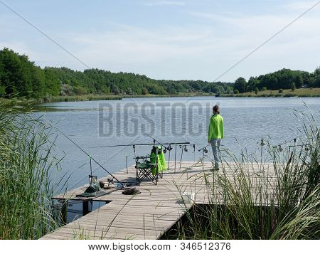 Girl Carp Fishing On Beautiful Blue Lake With Carp Rods And Rod Pods In The Summer Morning. Fishing 