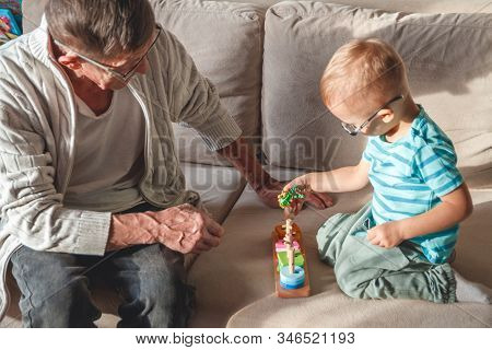 Elderly Grandpa Or Grandfather Plays With His Little Grandson