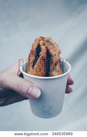 Woman Is Holding Hot Korean Sweet Pancake - Hotteok In White Paper Cup