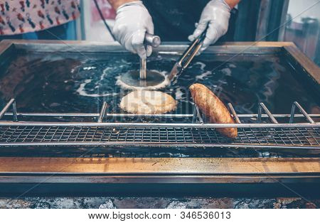 Woman Frying Korean Sweet Pancakes-hotteok In Hot Oil