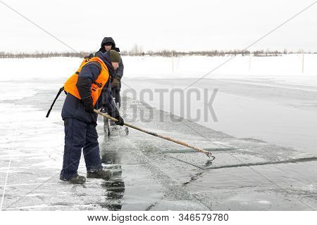 Worker Rafts Ice Blocks Along A Canal Carved In A Frozen Lake