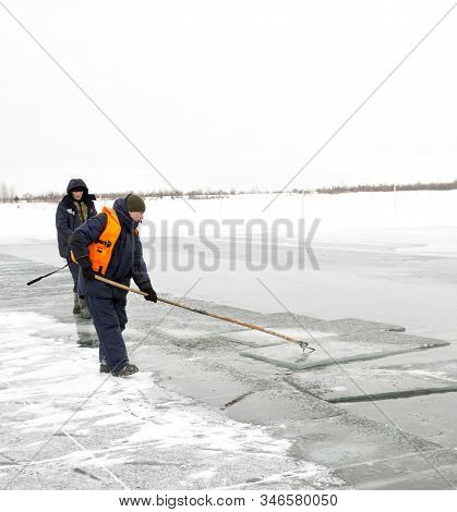 Worker Rafts Ice Blocks Along A Canal Carved In A Frozen Lake