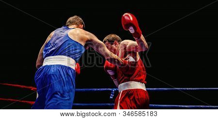 Boxer Blow To Body Opponent During Boxing Match On Black Background