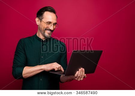 Photo Of Cheerful Happy Handsome Freelancer Browsing Through His Laptop In Search Of New Information