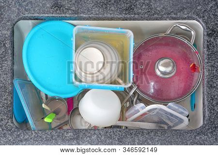 Dirty Dishes, Utensils In The Ceramic Sink Background. Pile Of Dirty Dishes In The Ceramic Sink. Top