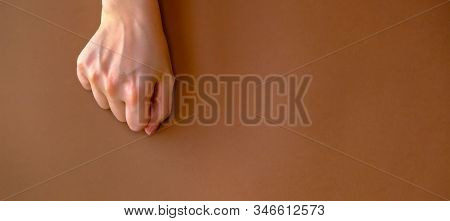 Womans Hand On Brown Background. Flat Lay Style.