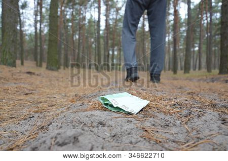 Young Man Loses His Euro Money Bills On Russian Autumn Fir Wood Path. Carelessness And Losing Money 