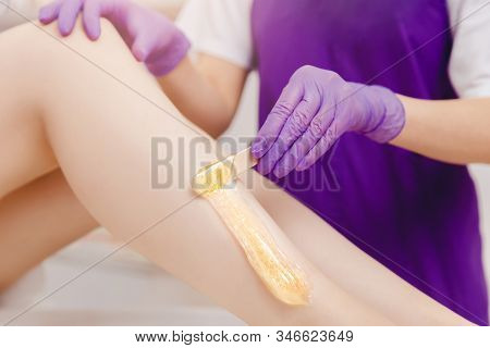 Hair Removal Procedure Sugaring On Leg Of Woman With Sugar Paste In Salon